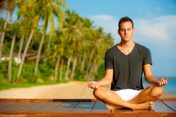 mindfulness meditation man sits and meditates on beach