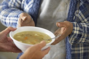 Bowl of chicken noodle soup being handed out