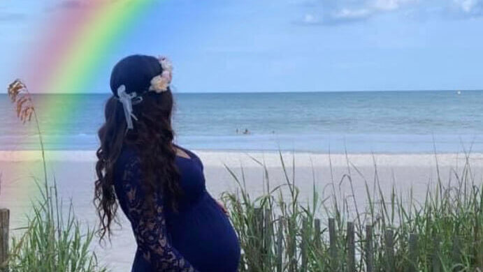 woman on beach with rainbow
