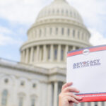 person holding folder in front of Capitol